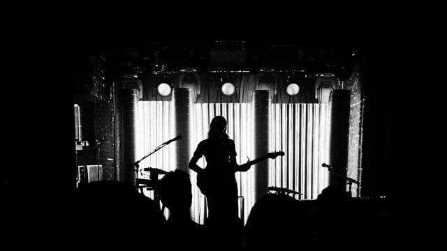 Person with Guitar Black performing on stage 