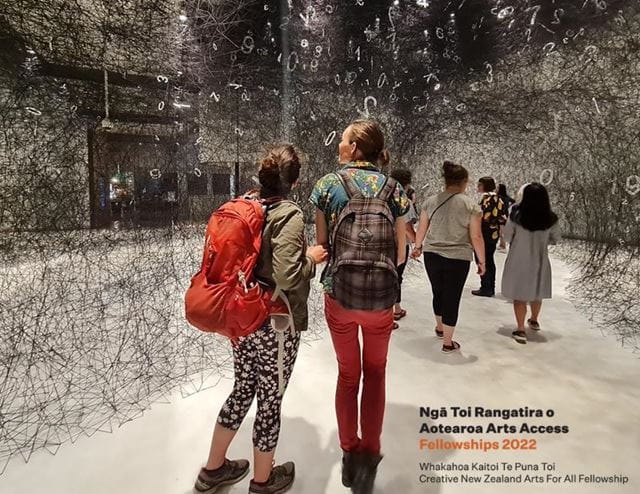 Visitors to Te Papa enjoy a Sense Art tour of an installation, called Web of Time. In the foreground, a person with a red pack of her back, holds the elbow of her companion