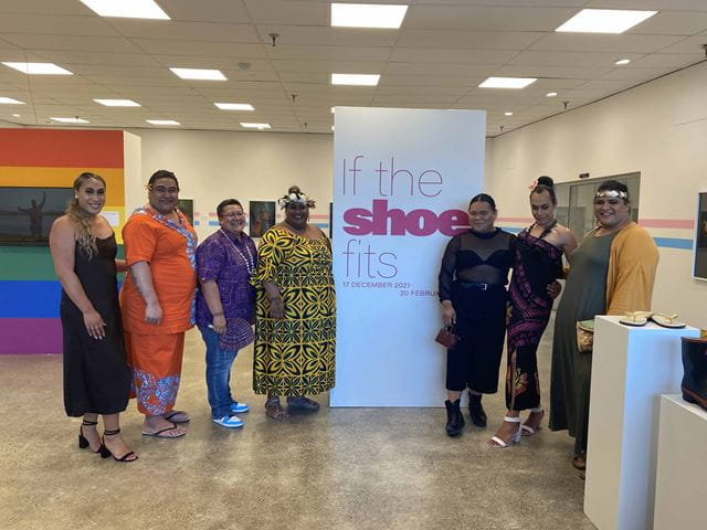 Members of the Pasifika Rainbow community pose in front of  the exhibition 'If the shoe fits', by Sevia Aliiva'a Nua.